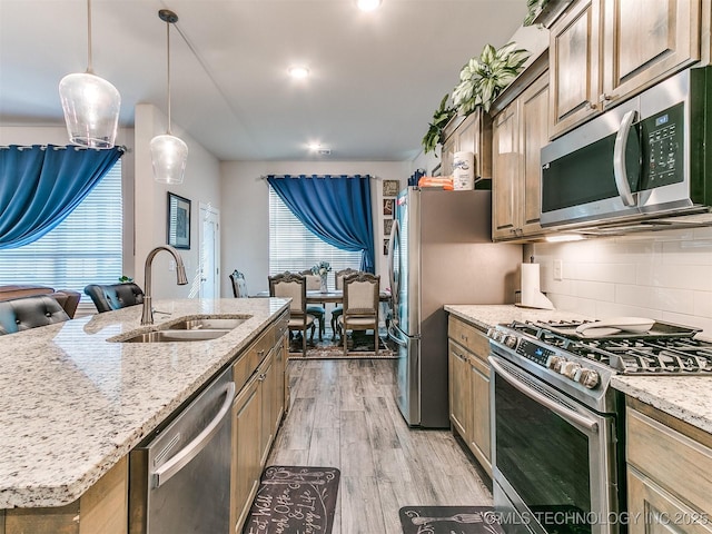 6342 E 148th St S, Bixby, OK 74008 - kitchen featuring stainless steel appliances, a sink, light wood-style floors, decorative backsplash, and light stone counters