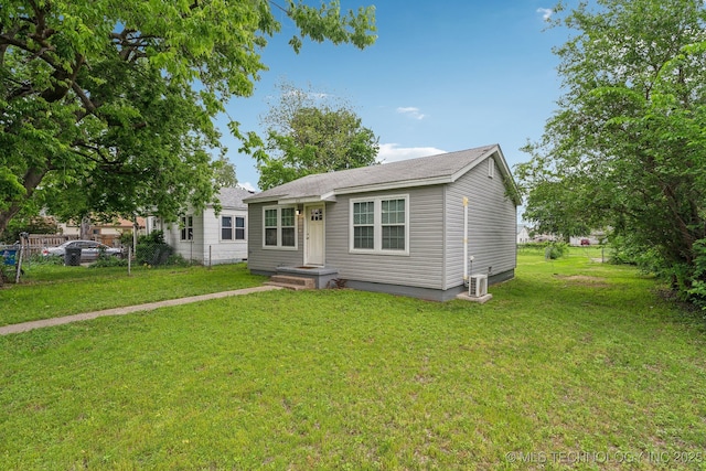 view of front of home with fence, central AC unit, and a front yard