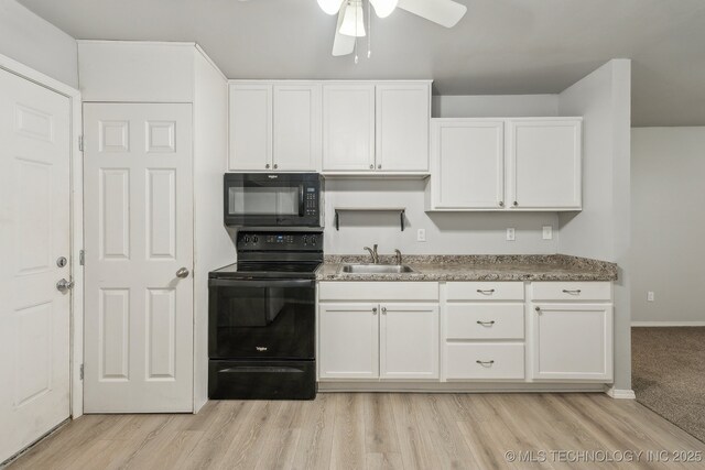 kitchen with ceiling fan, a sink, black appliances, light wood-style floors, and white cabinetry