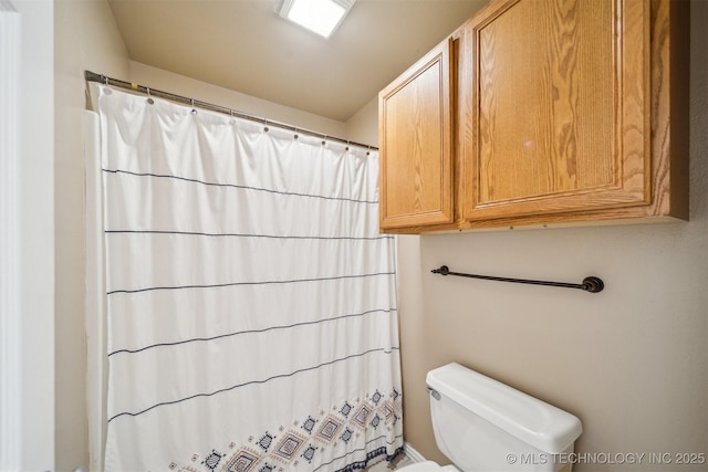 full bath with a shower with shower curtain and toilet