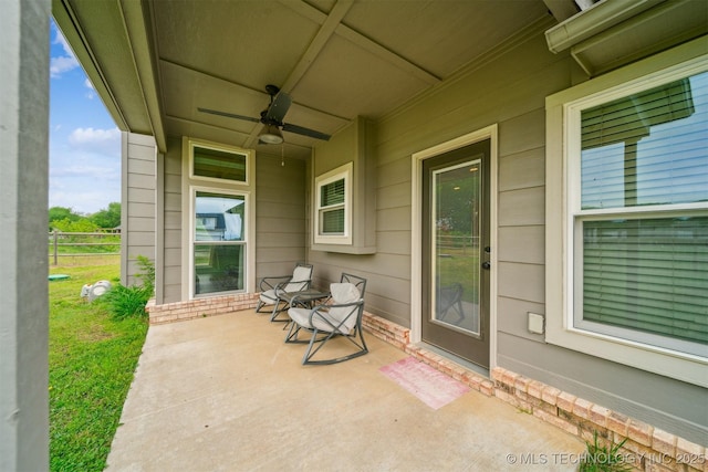 view of patio with fence and a ceiling fan