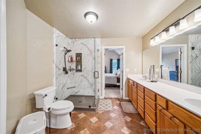 full bathroom featuring double vanity, toilet, a sink, a marble finish shower, and ensuite bath