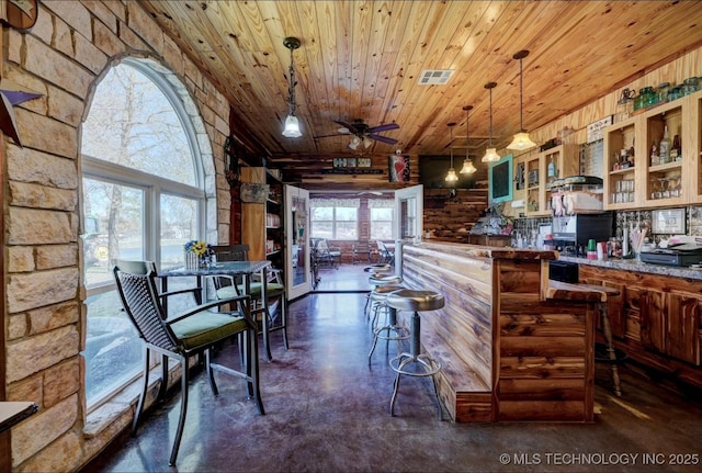 kitchen featuring visible vents, finished concrete flooring, glass insert cabinets, wooden ceiling, and a ceiling fan