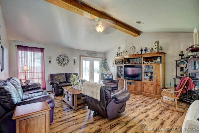 living area with french doors, visible vents, vaulted ceiling with beams, and wood finished floors