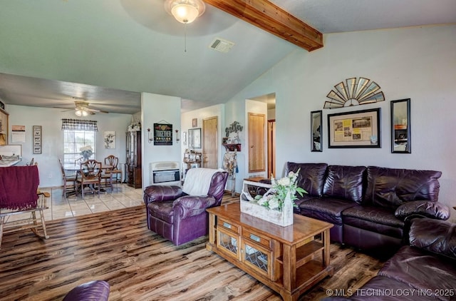living room with lofted ceiling with beams, a ceiling fan, light wood-type flooring, and visible vents