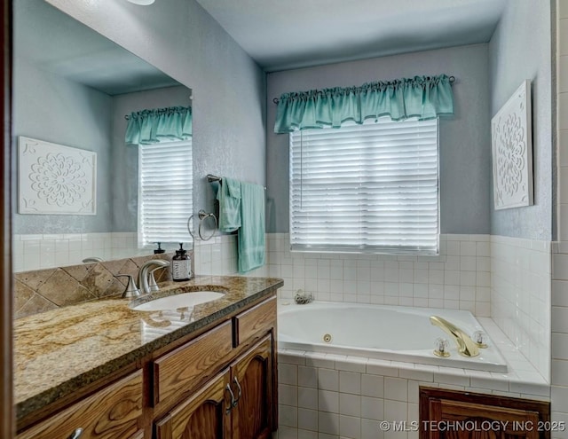 full bathroom featuring plenty of natural light, a whirlpool tub, and vanity