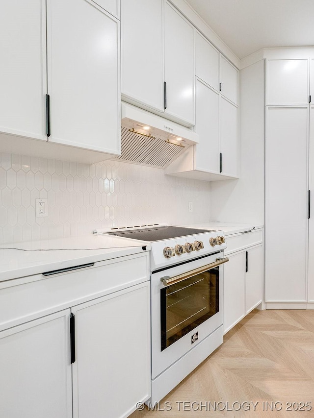 kitchen with electric range, tasteful backsplash, light countertops, under cabinet range hood, and white cabinetry