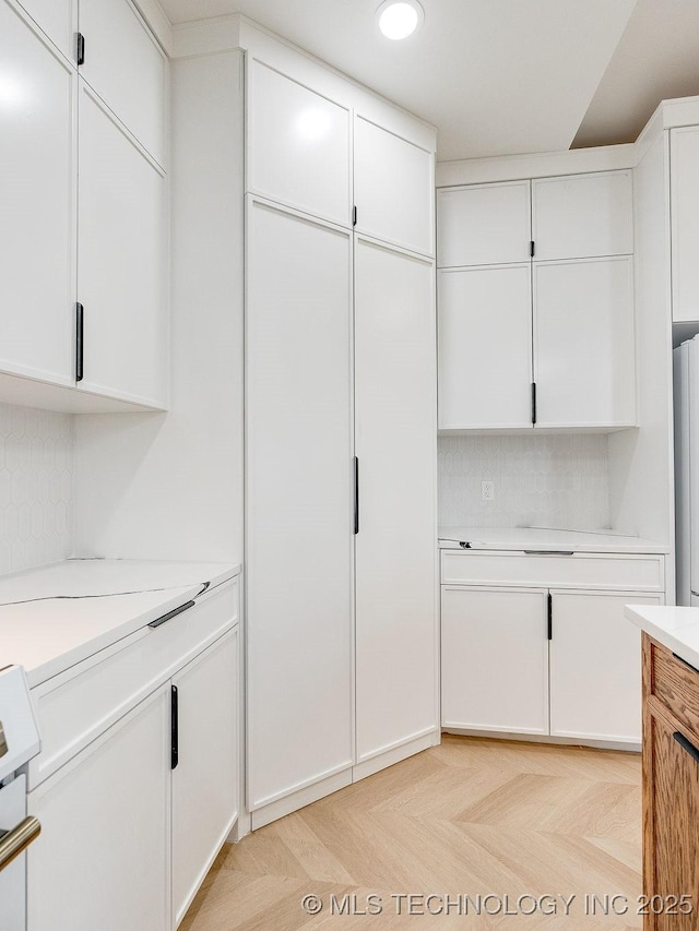 interior space with recessed lighting, light countertops, and white cabinets