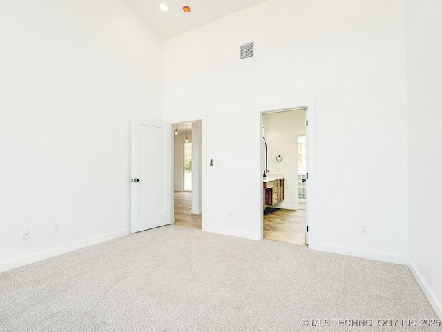 unfurnished bedroom featuring visible vents, carpet flooring, baseboards, and multiple windows