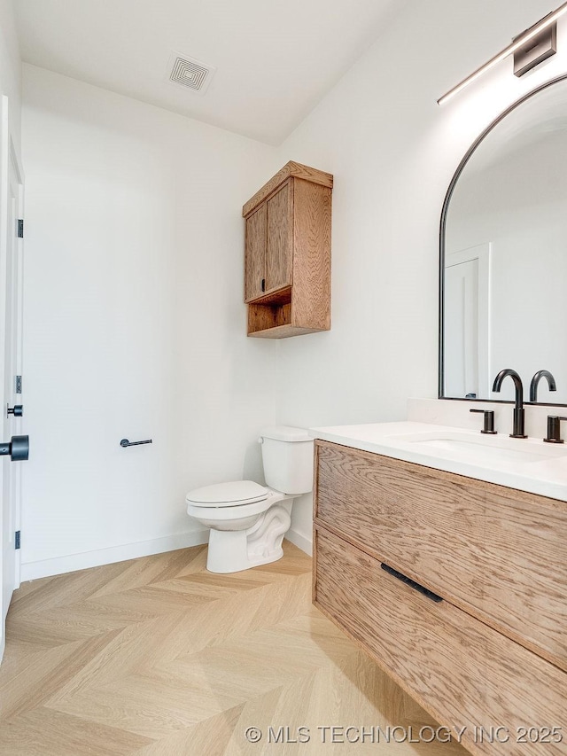 bathroom featuring visible vents, baseboards, toilet, and vanity