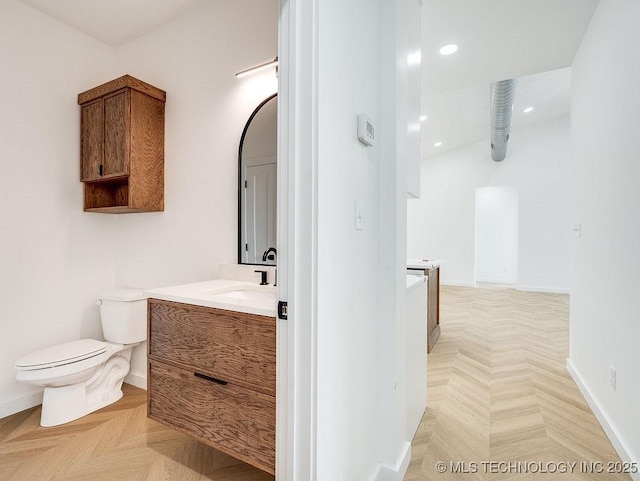 bathroom featuring recessed lighting, vanity, baseboards, and toilet