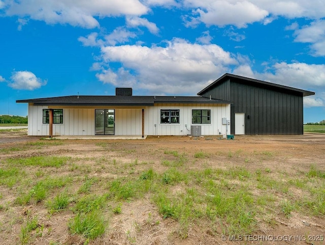 back of house with board and batten siding, a patio, and central AC unit