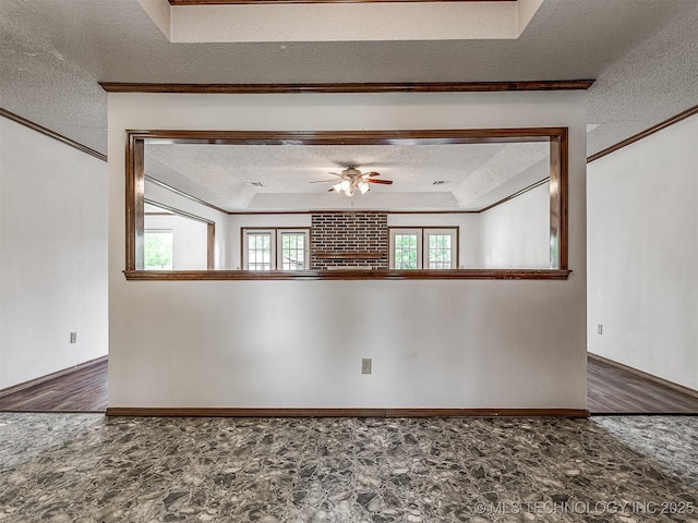 spare room with ornamental molding, a textured ceiling, a ceiling fan, and stone finish flooring