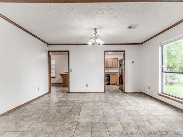 empty room with a chandelier, a textured ceiling, visible vents, and ornamental molding