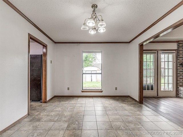 unfurnished room featuring baseboards, ornamental molding, a textured ceiling, and a notable chandelier