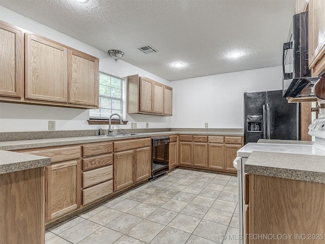 kitchen with a sink, black appliances, a textured ceiling, and visible vents