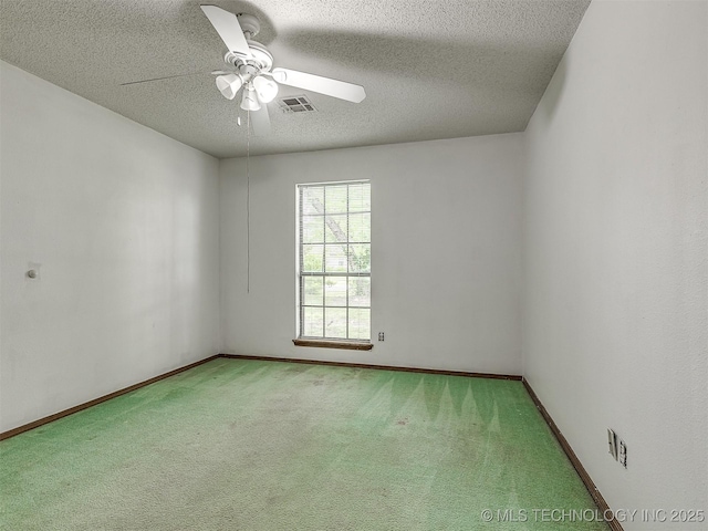 unfurnished room with carpet flooring, a ceiling fan, a textured ceiling, and visible vents