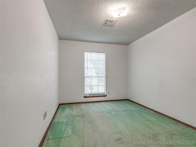 carpeted empty room with baseboards, a textured ceiling, and visible vents