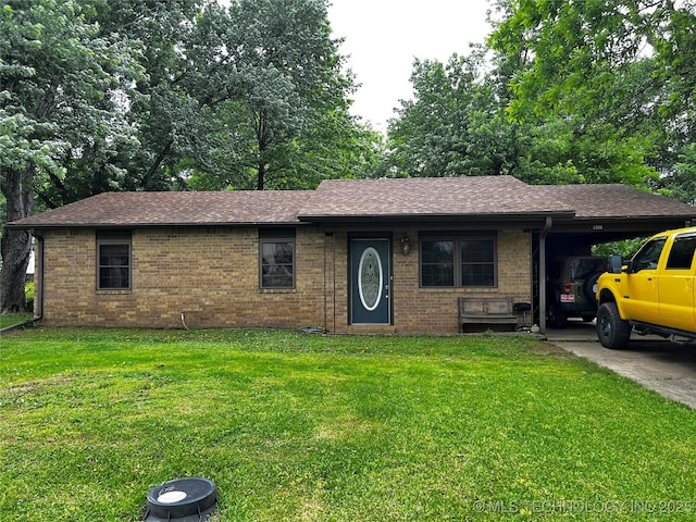 ranch-style home featuring roof with shingles, a front yard, and brick siding