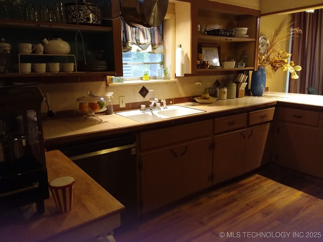 kitchen with open shelves, a sink, tile counters, black dishwasher, and dark wood-type flooring