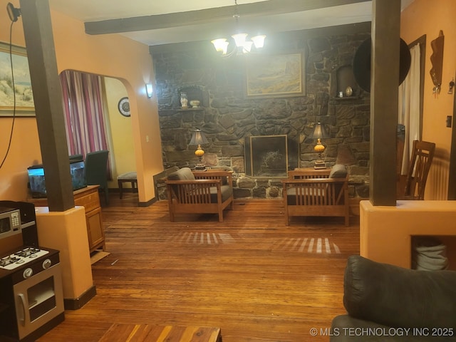 1324 E Hickory St, Okmulgee, OK 74447 - living area with wood-type flooring, arched walkways, an inviting chandelier, and beam ceiling