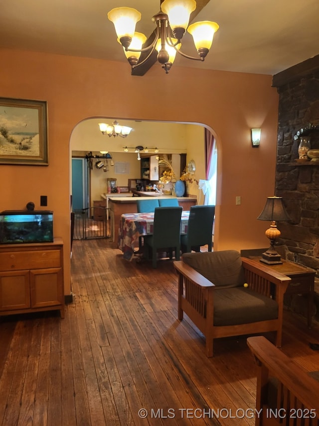 1324 E Hickory St, Okmulgee, OK 74447 - living room featuring an inviting chandelier, arched walkways, and dark wood finished floors