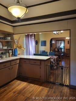 1324 E Hickory St, Okmulgee, OK 74447 - kitchen featuring crown molding, light countertops, arched walkways, and dark wood-style floors