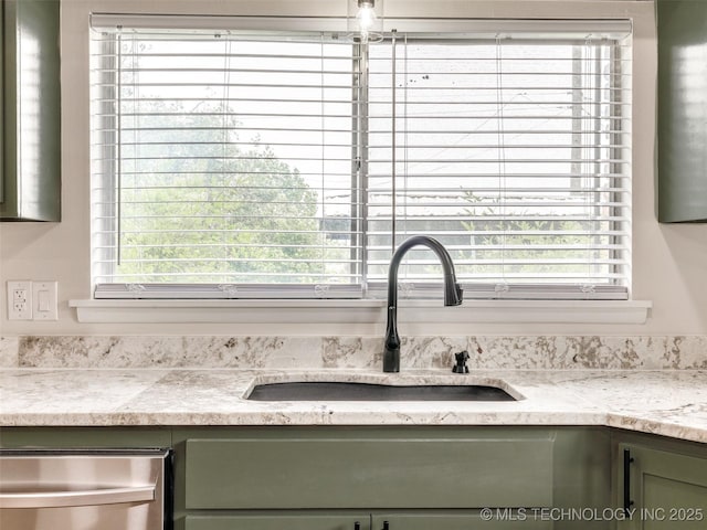 interior details with a sink, green cabinetry, and stainless steel dishwasher