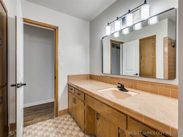 bathroom featuring vanity, decorative backsplash, and baseboards