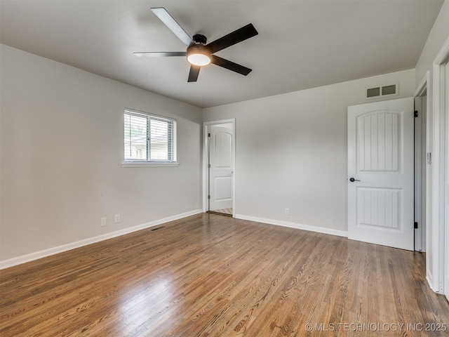 unfurnished bedroom featuring baseboards, ceiling fan, wood finished floors, and visible vents