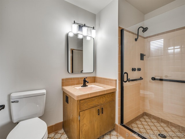 full bath featuring toilet, a shower stall, and vanity