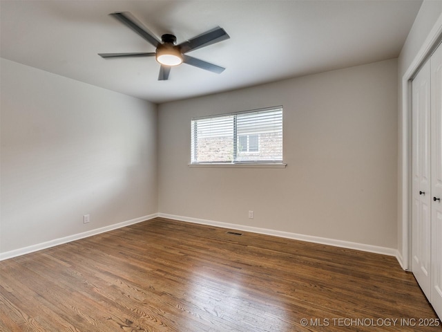 unfurnished bedroom featuring baseboards, a closet, wood finished floors, and visible vents