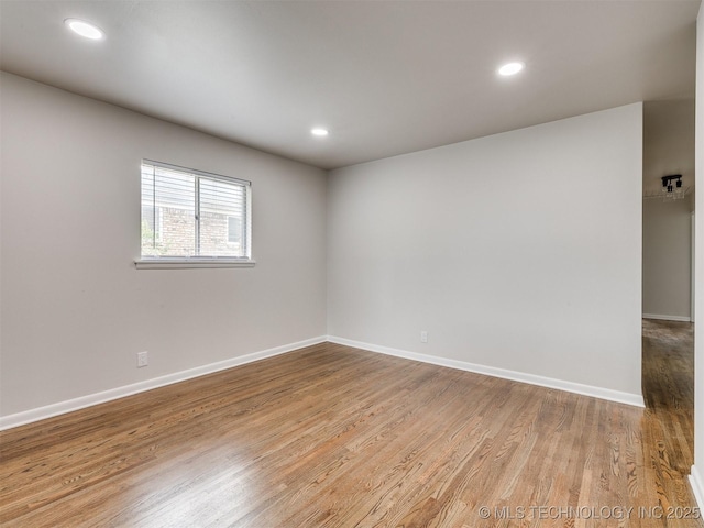 spare room with recessed lighting, baseboards, and wood finished floors