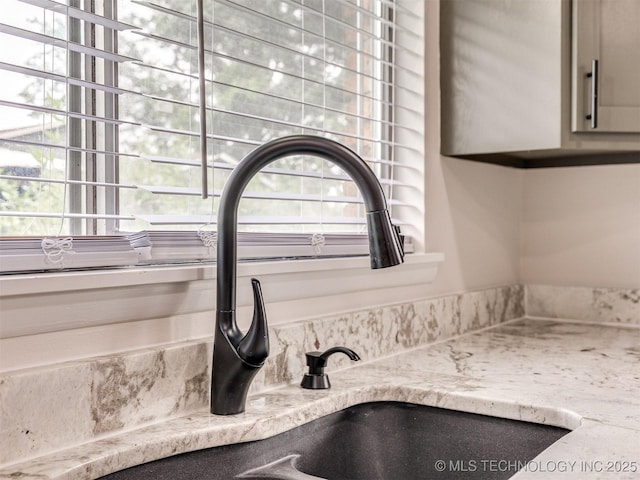 room details with light stone counters and a sink