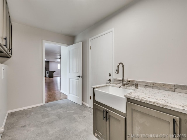 washroom with baseboards and a sink