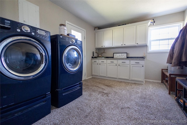 laundry area featuring separate washer and dryer, baseboards, light carpet, and cabinet space