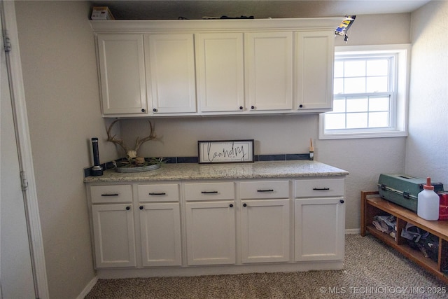 interior space with baseboards and light carpet