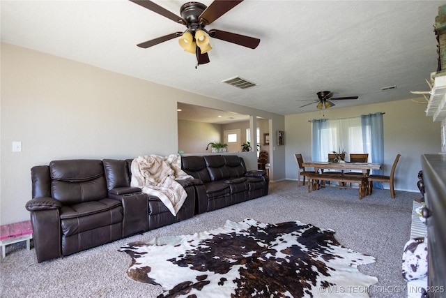 living area featuring carpet floors, a ceiling fan, baseboards, and visible vents