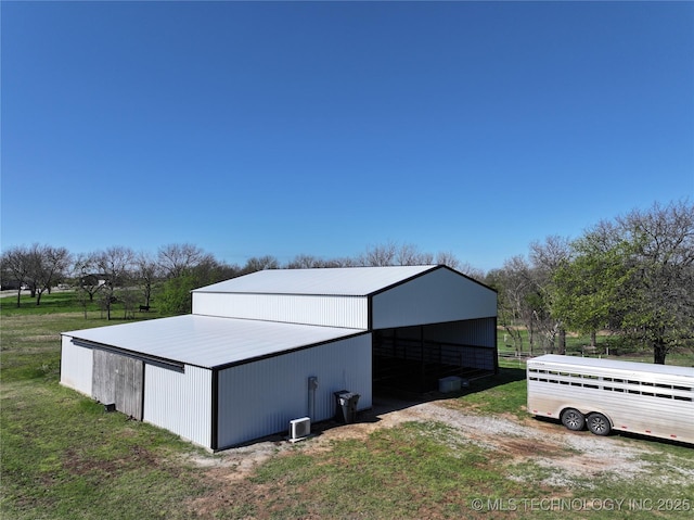 view of pole building featuring a lawn and a carport