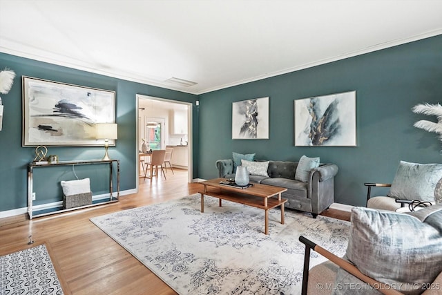living area featuring visible vents, ornamental molding, and wood finished floors