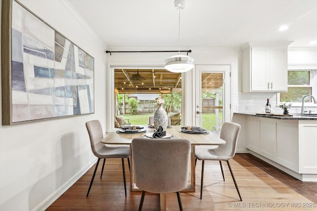 dining room featuring crown molding, recessed lighting, and light wood-type flooring