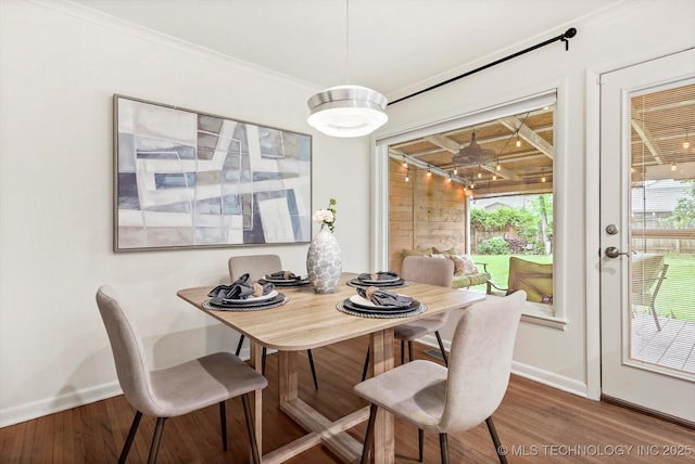 dining space featuring baseboards, ornamental molding, and wood finished floors