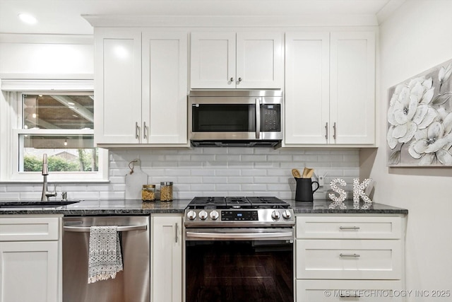 kitchen with backsplash, stainless steel appliances, white cabinetry, and a sink