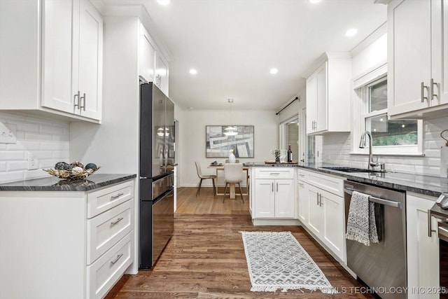 kitchen with dark wood-style flooring, stainless steel appliances, white cabinetry, and a sink