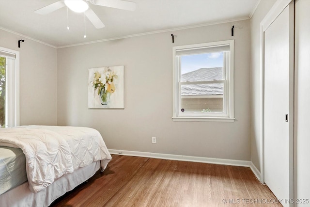 bedroom featuring baseboards, ornamental molding, ceiling fan, and wood finished floors