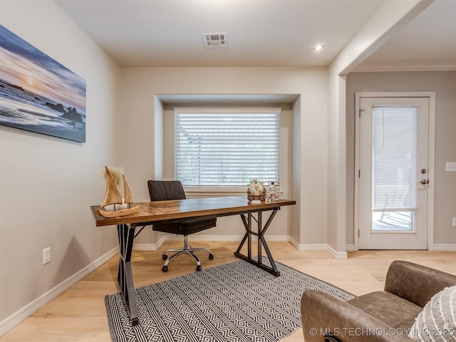 home office featuring visible vents, light wood-style flooring, and plenty of natural light