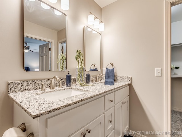 bathroom with double vanity, a sink, and ceiling fan