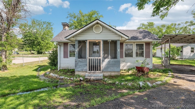25505 S 4111th Rd, Claremore, OK 74019 - bungalow featuring roof with shingles, a chimney, a front yard, and a carport