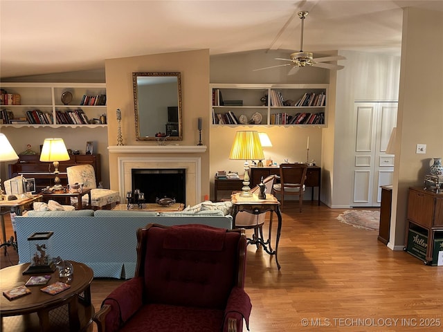 2124 E 60th Ct Unit O-4, Tulsa, OK 74105 - living area featuring vaulted ceiling, wood finished floors, a ceiling fan, a fireplace, and built in shelves