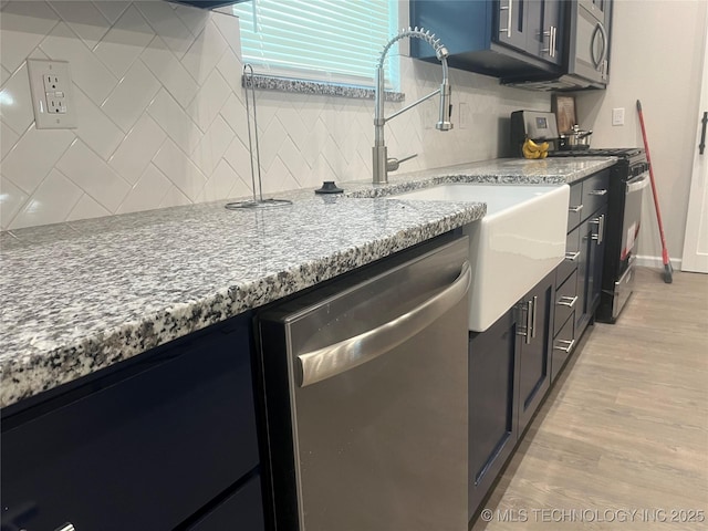 5114 W 3rd St, Tulsa, OK 74127 - kitchen with light stone counters, appliances with stainless steel finishes, light wood-style flooring, and tasteful backsplash